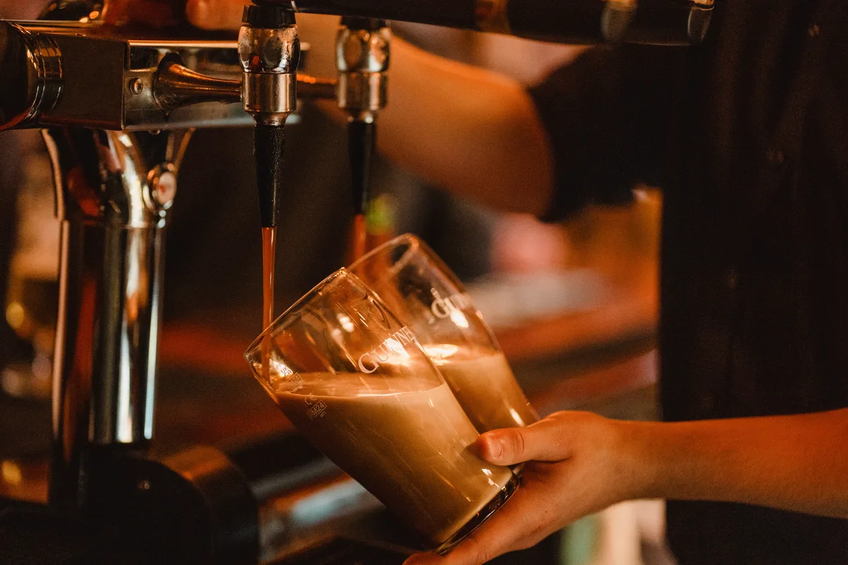 Two glasses of Guinness settling during the slow draught pour at the Anchor bar