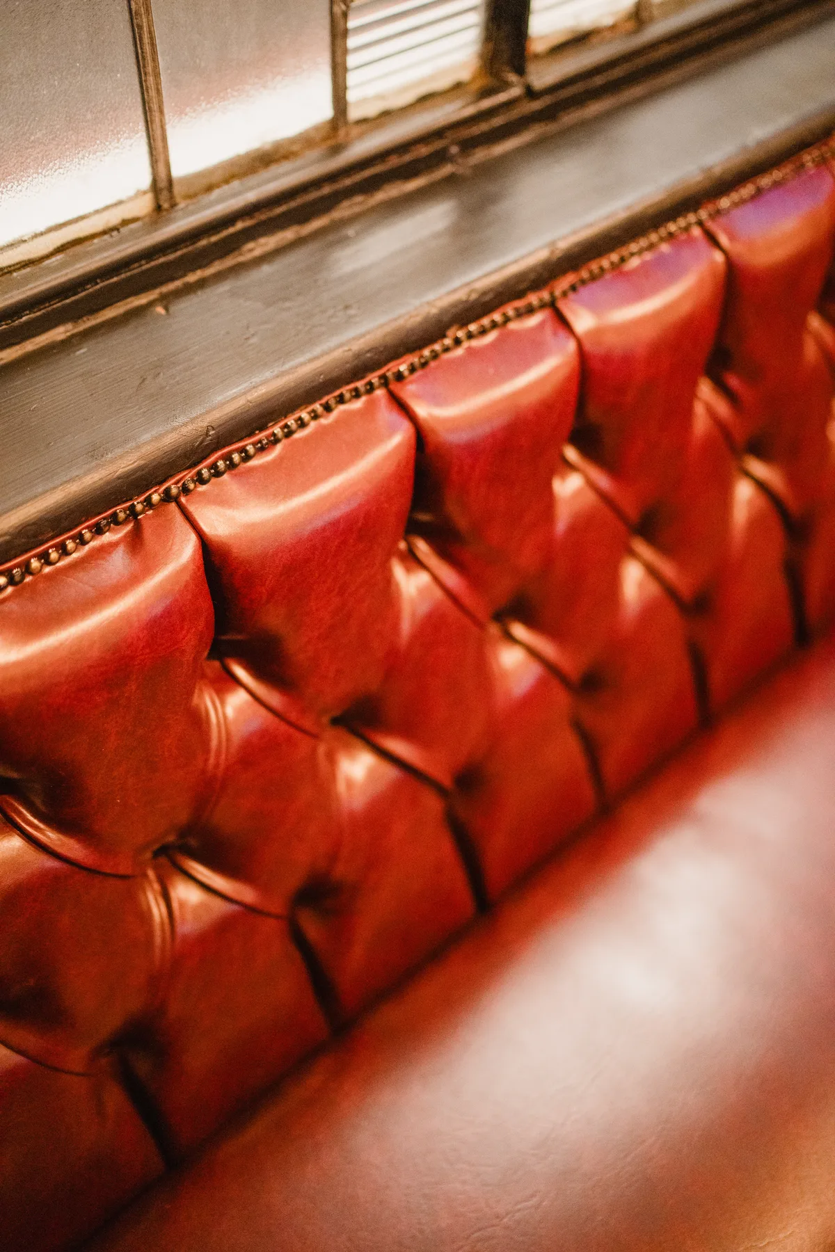 Carrickfergus Red tufted leather banquette seating in the public bar at The Anchor Digbeth